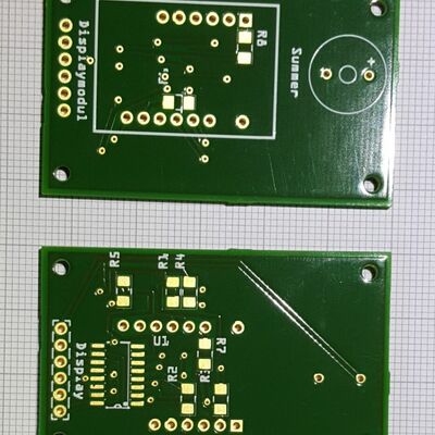 The bare Displaymodul PCBs: the top with the buzzer and 7-segment digit footprints, the bottom with the 74HC595 and the eight segment-resistor pads.